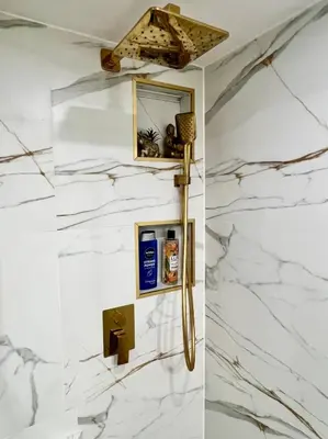 a bathroom with white marble walls and a mirror at Nowoczesny Apartament w Centrum Krakowa in Kraków