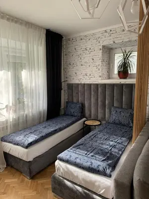 a bedroom with two beds and a brick wall at Juli Apart in Kraków