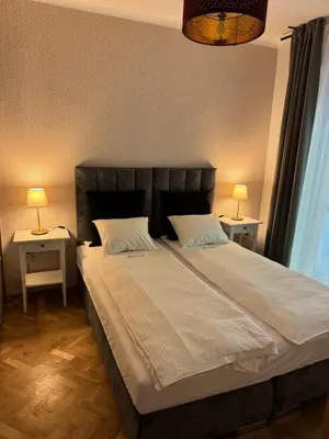 a bedroom with a large bed with two side tables at Juli Apart in Kraków
