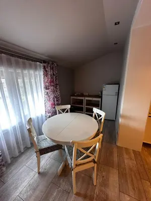 a table and chairs in a room with a kitchen at Apartamenty Czerwona Róża in Wieprz