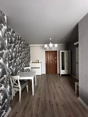 an empty living room with a table and a kitchen at Apartamenty Czerwona Róża in Wieprz