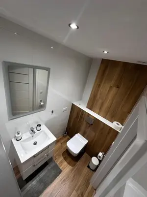 a bathroom with a sink and a toilet and a mirror at Apartamenty Czerwona Róża in Wieprz