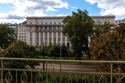 a large white building with trees in front of it at Charming Loft in the Old Town in Kraków