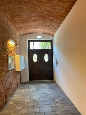 a hallway with a door and a brick wall at Charming Loft in the Old Town in Kraków