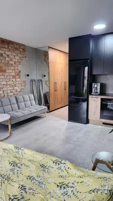 a living room with a couch and a kitchen at Your time in Heart of Cracow , Gym & free parking in Kraków