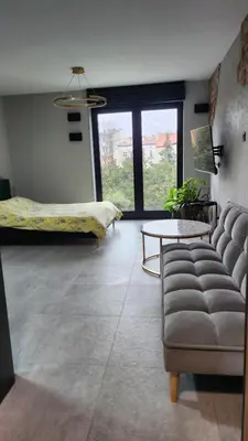 a living room with a couch and a table at Your time in Heart of Cracow , Gym & free parking in Kraków