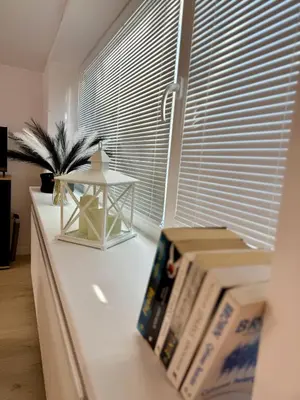 a white counter with books on it with a window at Apartamenty Oracka Przystań Solna 1 in Bochnia