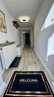 a hallway with a welcome rug on the floor at Apartamenty Oracka Przystań Solna 1 in Bochnia