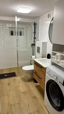 a bathroom with a washer and a washing machine at Apartamenty Oracka Przystań Solna 1 in Bochnia