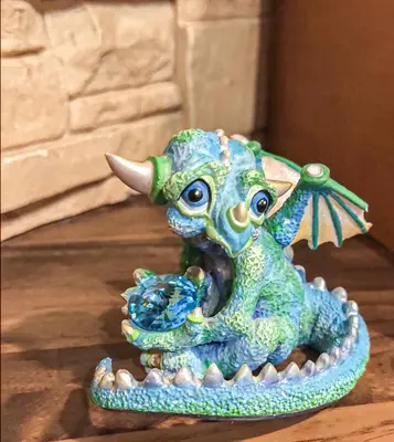 a blue and green dragon figurine sitting on a table at Sweet Home Apartament in Kraków