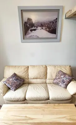 a couch in a living room with a picture on the wall at Sweet Home Apartament in Kraków