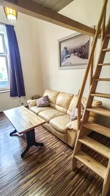 a living room with a couch and a staircase at Sweet Home Apartament in Kraków