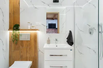 a bathroom with a white sink and a shower at Apartamenty przy Kładce- Kazimierz Old Town in Kraków