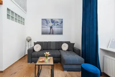 a living room with a couch and a table at Apartamenty przy Kładce- Kazimierz Old Town in Kraków
