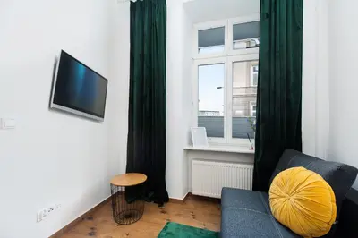 a living room with a couch and a window at Apartamenty przy Kładce- Kazimierz Old Town in Kraków
