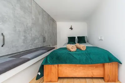 a bedroom with a bed with two pillows on it at Apartamenty przy Kładce- Kazimierz Old Town in Kraków