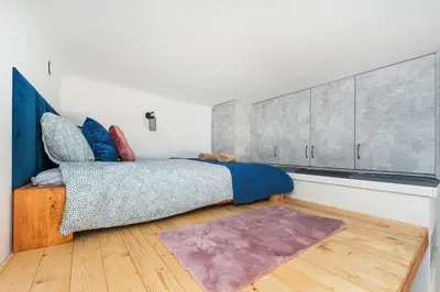 a bedroom with a bed and a wooden floor at Apartamenty przy Kładce- Kazimierz Old Town in Kraków