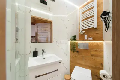 a bathroom with a white sink and a shower at Apartamenty przy Kładce- Kazimierz Old Town in Kraków