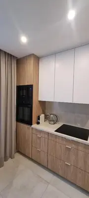 a kitchen with white cabinets and a counter top at Apartament Zabawa in Wieliczka