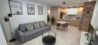a living room with a couch and a table and a kitchen at Apartament Zabawa in Wieliczka