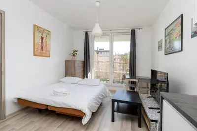 a white bedroom with a bed and a desk at Borkowska Corner in Kraków