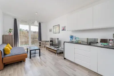 a kitchen and living room with a couch and a table at Borkowska Corner in Kraków