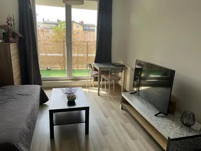 a living room with a flat screen tv and a table at Borkowska Corner in Kraków