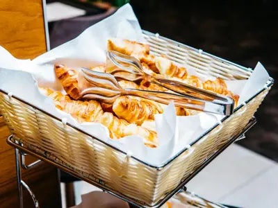 a basket of food with spoons and bread at Q Hotel Plus Kraków in Kraków