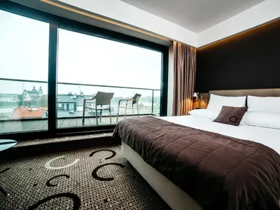 a hotel room with a bed and a large window at Q Hotel Plus Kraków in Kraków