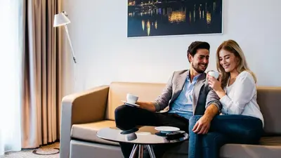 a man and a woman sitting on a couch at Q Hotel Plus Kraków in Kraków