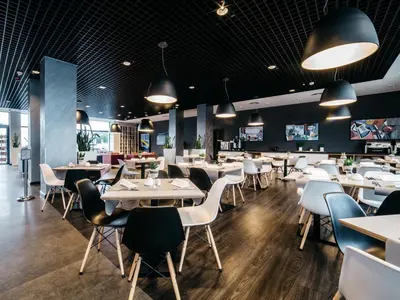 a dining room with white tables and chairs at Q Hotel Kraków in Kraków