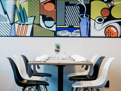 a table with chairs and a painting on the wall at Q Hotel Kraków in Kraków