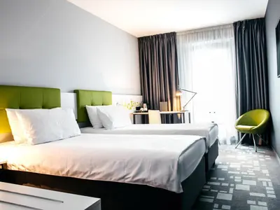 a hotel room with two beds and a window at Q Hotel Kraków in Kraków