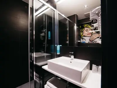 a bathroom with a sink and a mirror at Q Hotel Kraków in Kraków