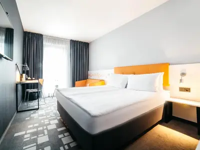 a hotel room with a bed and a desk at Q Hotel Kraków in Kraków