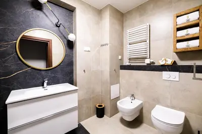 a bathroom with a sink and a toilet and a mirror at Family AC apartment Old Town Main Railway Station in Kraków