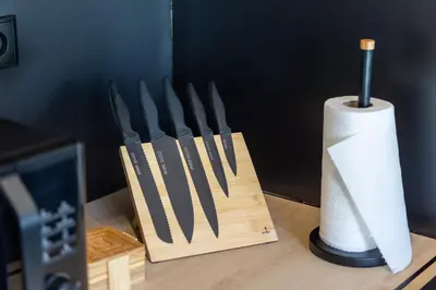 a wooden block of knives and a roll of paper towels at Piotrowiczówka Osada w Szczyrzycu in Szczyrzyc
