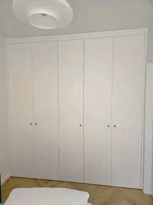 a bedroom with white wardrobes at Wawel View Stylish Apartment in Kraków