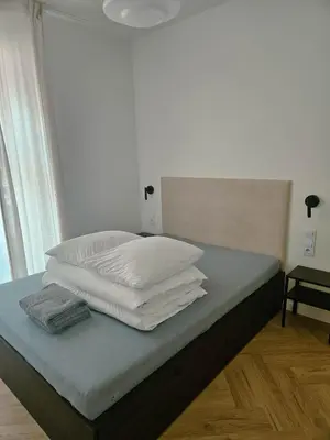 a bed with white pillows on top of it at Wawel View Stylish Apartment in Kraków