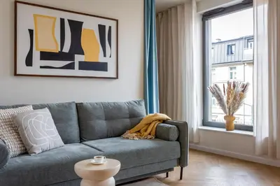 a living room with a couch and a window at Wawel View Stylish Apartment in Kraków