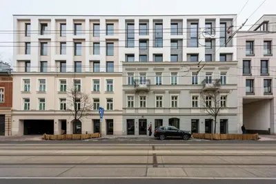 a large white building with a car parked in front of it at Wawel View Stylish Apartment in Kraków