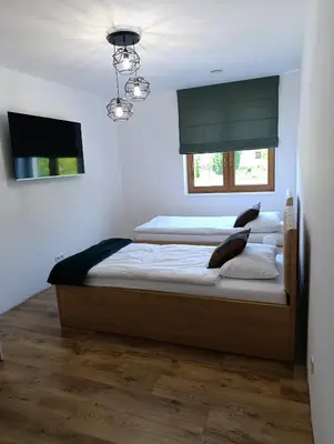 a bedroom with two beds and a flat screen tv at Centrum Konferencyjno-Noclegowe in Iwkowa