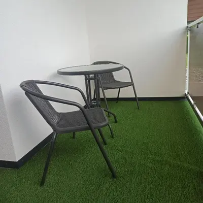 two chairs and a table in a room with green carpet at Centrum Konferencyjno-Noclegowe in Iwkowa