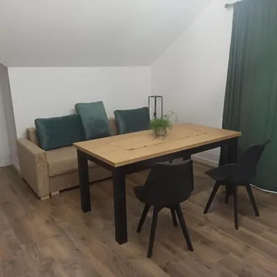 a table and chairs in a living room with a couch at Centrum Konferencyjno-Noclegowe in Iwkowa