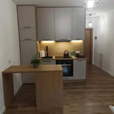 a kitchen with white cabinets and a wooden counter top at Centrum Konferencyjno-Noclegowe in Iwkowa