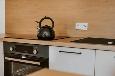 a black tea kettle sitting on a stove in a kitchen at Centrum Konferencyjno-Noclegowe in Iwkowa