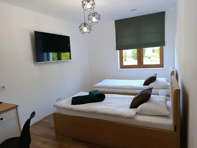 two twin beds in a room with a tv at Centrum Konferencyjno-Noclegowe in Iwkowa