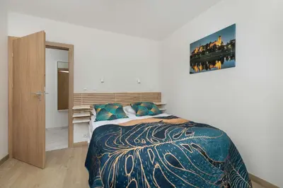 a bedroom with a bed and a picture on the wall at Cozy Apartments Łaszkiewicza with Parking by Noclegi Renters in Kraków
