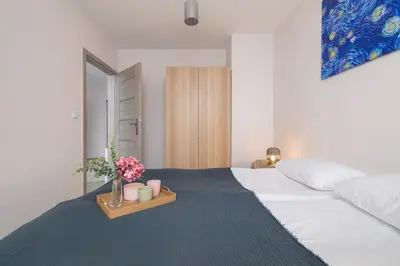 a bedroom with a bed with a tray with flowers on it at Cozy Apartments Łaszkiewicza with Parking by Noclegi Renters in Kraków