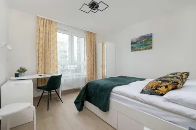 a bedroom with a bed and a desk and a window at Cozy Apartments Łaszkiewicza with Parking by Noclegi Renters in Kraków